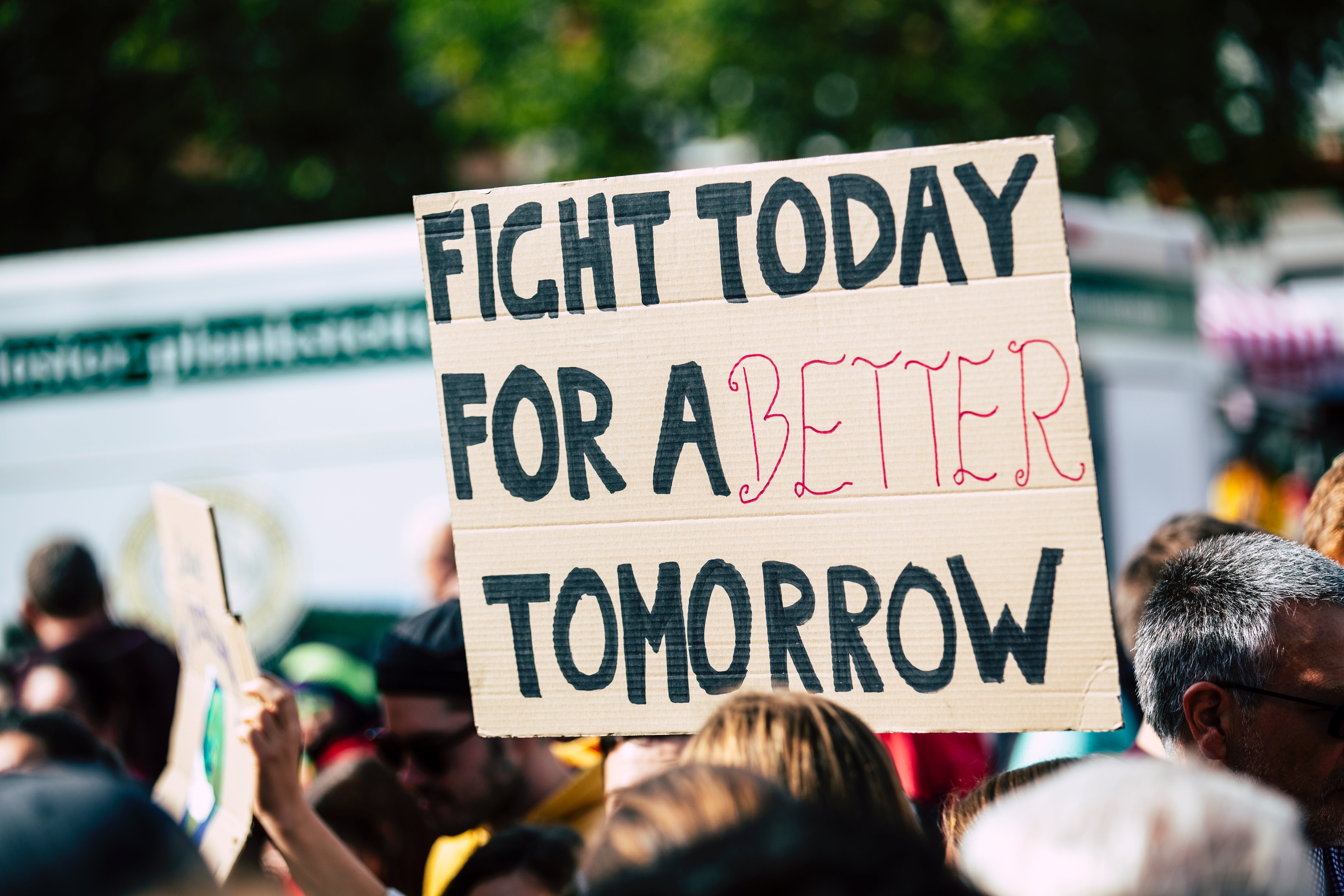 Image of a protest with a man holding a sign that says No Justice No Peace.