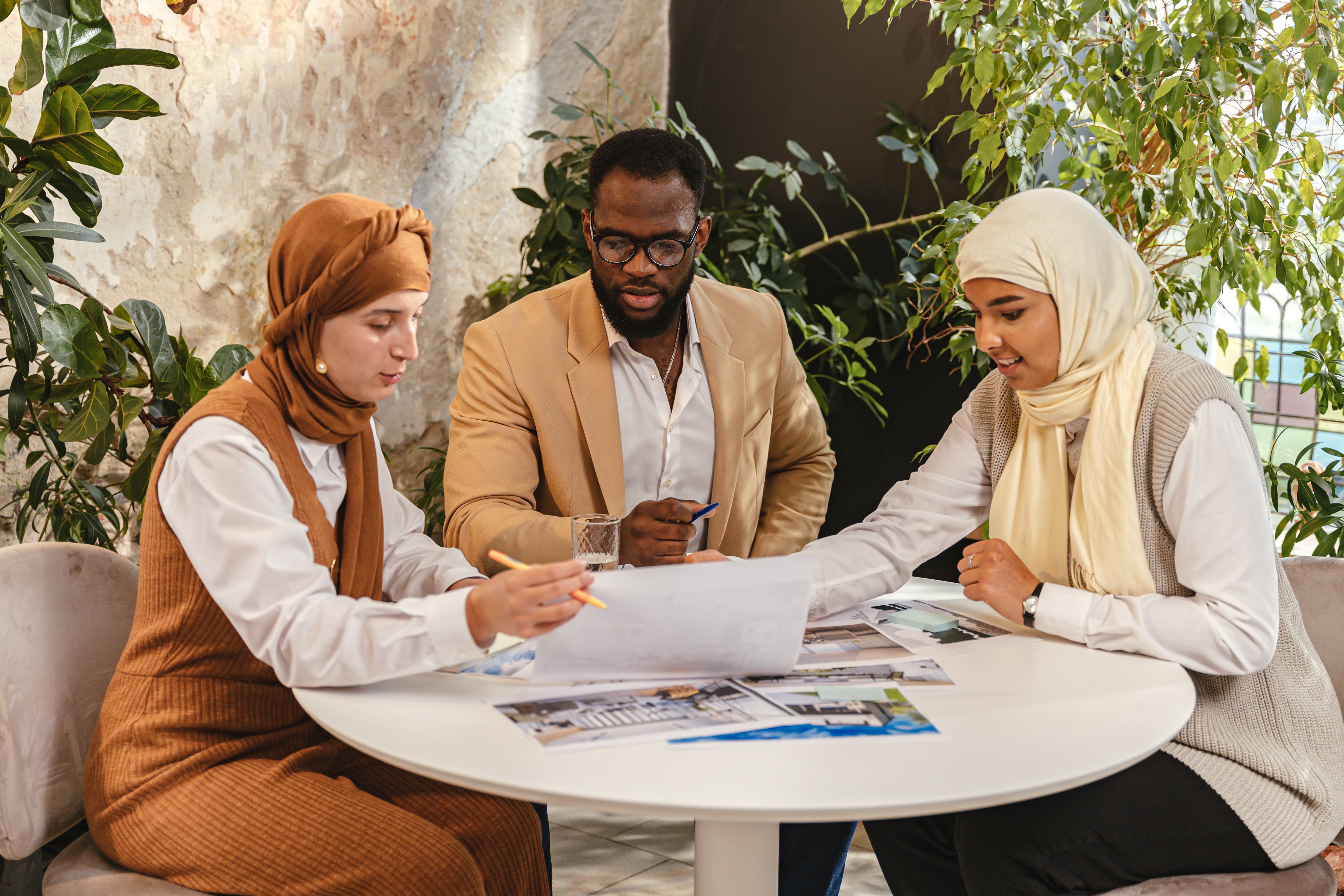 Three individuals sitting at a table working on a project.